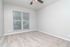 Bright and inviting room with plush carpeting, large window, and modern ceiling fan, perfect for relaxation.