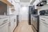 Modern kitchen with sleek black appliances, elegant marble countertops, and bright cabinetry creating a spacious and inviting cooking area.