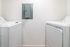 Modern apartment laundry room featuring sleek washer and dryer units against a fresh white backdrop.