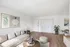 Bright, airy living room with elegant decor, featuring a plush sofa, stylish artwork, and light wood flooring. Natural light enhances the modern ambiance.