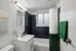 Chic bathroom with a modern vanity, stylish black tiles, and vibrant green accents for a refreshing vibe.