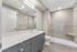 Bright, modern bathroom featuring sleek cabinetry, a spacious vanity, and a luxurious glass-enclosed shower.