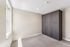Bright, modern bedroom with plush carpeting and a sleek built-in wardrobe.