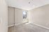 Bright and inviting room with plush carpet, neutral walls, and natural light streaming through a window.