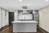 Sleek modern kitchen with stainless steel appliances, large island, and elegant gray cabinetry, ideal for contemporary living.