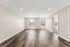 Bright and spacious living room with sleek hardwood floors and large windows offering ample natural light.