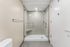 Elegant modern bathroom with sleek glass shower enclosure and stylish tile design, perfect for a contemporary apartment.