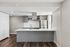 Modern kitchen with sleek gray cabinetry, stainless steel appliances, and a stylish white island countertop.