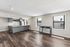 Contemporary open floor plan with sleek gray kitchen, bright living area, and elegant wood flooring, perfect for modern city living.