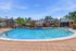 Inviting apartment complex showcasing a sparkling outdoor swimming pool surrounded by lush greenery and modern architecture.