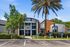 Inviting leasing office with modern architecture, surrounded by lush greenery and palm trees, offers a welcoming atmosphere for visitors.