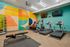 Modern apartment gym with state-of-the-art exercise bikes, treadmills, and a vibrant teal interior.
