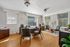 Bright and inviting office space with modern furniture, large windows, and elegant wood flooring.