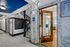 Charming apartment entryway featuring elegant marble walls, sleek black mailbox unit, and inviting wooden door leading to a well-lit office space.