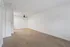 Bright and spacious living area with sleek hardwood flooring and a modern ceiling fan, offering a versatile design for any decor style.