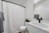 Modern bathroom with elegant marble countertop, stylish black faucet, and crisp white decor.