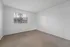 Bright bedroom with plush carpet and large window offering scenic views of lush greenery.