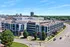 Modern urban apartment complex with stylish architecture, featuring green spaces and convenient parking in a vibrant neighborhood setting.
