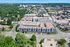 Vibrant aerial view of a modern apartment complex surrounded by lush greenery and a bustling urban landscape, showcasing convenient city living.