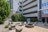 Modern apartment complex with inviting outdoor seating around a stylish stone fire pit, surrounded by lush greenery.