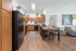 Inviting kitchen and dining area with warm wood cabinetry, sleek black appliances, and a cozy dining table, perfect for entertaining.