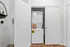Compact laundry nook featuring a modern stackable washer and dryer unit with convenient shelving for detergent storage.