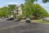 Charming apartment complex surrounded by lush greenery with convenient parking, offering a serene residential environment.