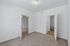 Inviting bedroom with plush carpet, neutral walls, and convenient access to an ensuite bathroom and hallway.