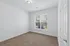 Bright, cozy room with plush carpeting, large window offering garden views, and elegant white walls.
