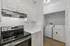 Modern kitchen with sleek stainless steel stove and adjacent laundry room featuring washer and dryer.