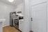 Modern kitchen design with sleek stainless steel appliances, white cabinetry, and elegant hardwood floors.