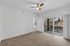 Bright, airy apartment with plush carpet, ceiling fan, and sliding glass door leading to private outdoor space.