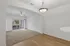 Bright apartment interior showcasing an open-plan living and dining area with modern light fixture and large sliding glass door to balcony.