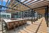 Modern apartment complex with a stylish outdoor patio featuring a pergola, bar seating, and comfortable lounge areas for relaxation and entertainment.