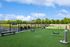 Vibrant outdoor space featuring a bright green lawn, agility equipment, and stylish outdoor seating, perfect for relaxation and entertainment.