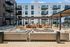 Upscale apartment building with modern outdoor lounge area featuring cozy seating, elegant pergolas, and stylish fire pits.