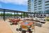 Inviting outdoor terrace showcasing modern seating areas, elegant fire pits, and dining tables with a backdrop of a chic apartment building.