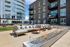 Modern outdoor patio with plush seating and stylish fire feature, set against sleek apartment buildings with expansive windows.