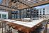Chic outdoor lounge area with wooden pergola, modern grill, and stylish seating, perfect for entertaining and relaxation.