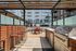 Contemporary outdoor space with sleek grilling station, stylish pergola, and inviting seating area, perfect for social gatherings in a modern apartment complex.