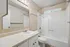 Bright and inviting bathroom featuring a spacious mirror, modern lighting, and elegant fixtures in a serene setting.