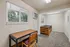 Inviting bedroom with cozy workspace, bright natural light from windows, and a comfortable wooden bed frame.