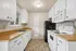 Bright kitchen with classic white cabinetry, sleek wooden countertops, and modern appliances for an inviting culinary space.