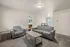 Inviting living area with plush gray seating, modern coffee table, and ample natural light, perfect for relaxation and entertaining.