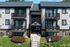 Charming and modern apartment facade with private balconies, surrounded by lush greenery and manicured landscaping.