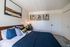 Elegant bedroom with modern art, cozy pillows, and a warm atmosphere, perfect for relaxation.