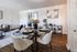 Elegant dining area in a modern apartment with sleek glass table, stylish seating, and contemporary decor.