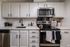 Contemporary kitchen with sleek stainless steel appliances, elegant white cabinetry, and modern black fixtures.
