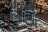 Stunning night view of a modern high-rise building featuring sleek glass architecture, illuminated windows, and rooftop pool with city reflections in a vibrant urban setting.