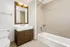 Elegant bathroom with a modern vanity and spacious bathtub in a serene, neutral-toned setting.